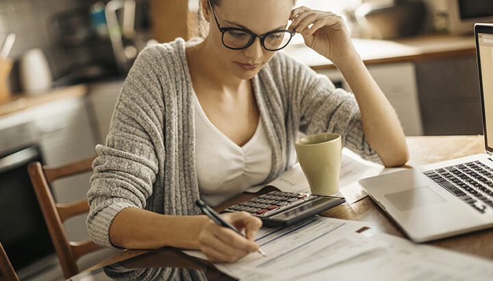 mulher fazendo sua organização financeira com uma calculadora
